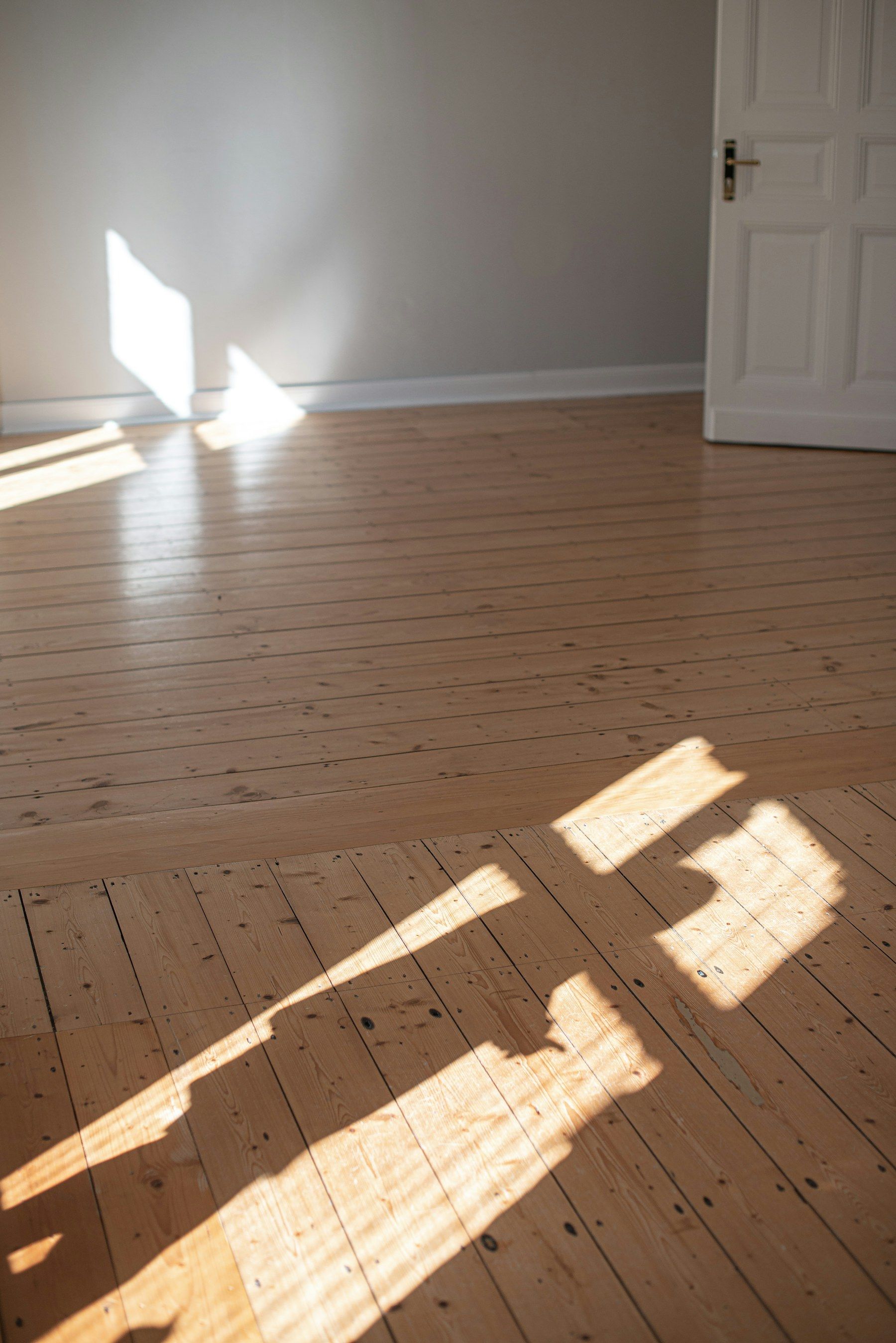 Sunlight across the wooden floor of an empty room