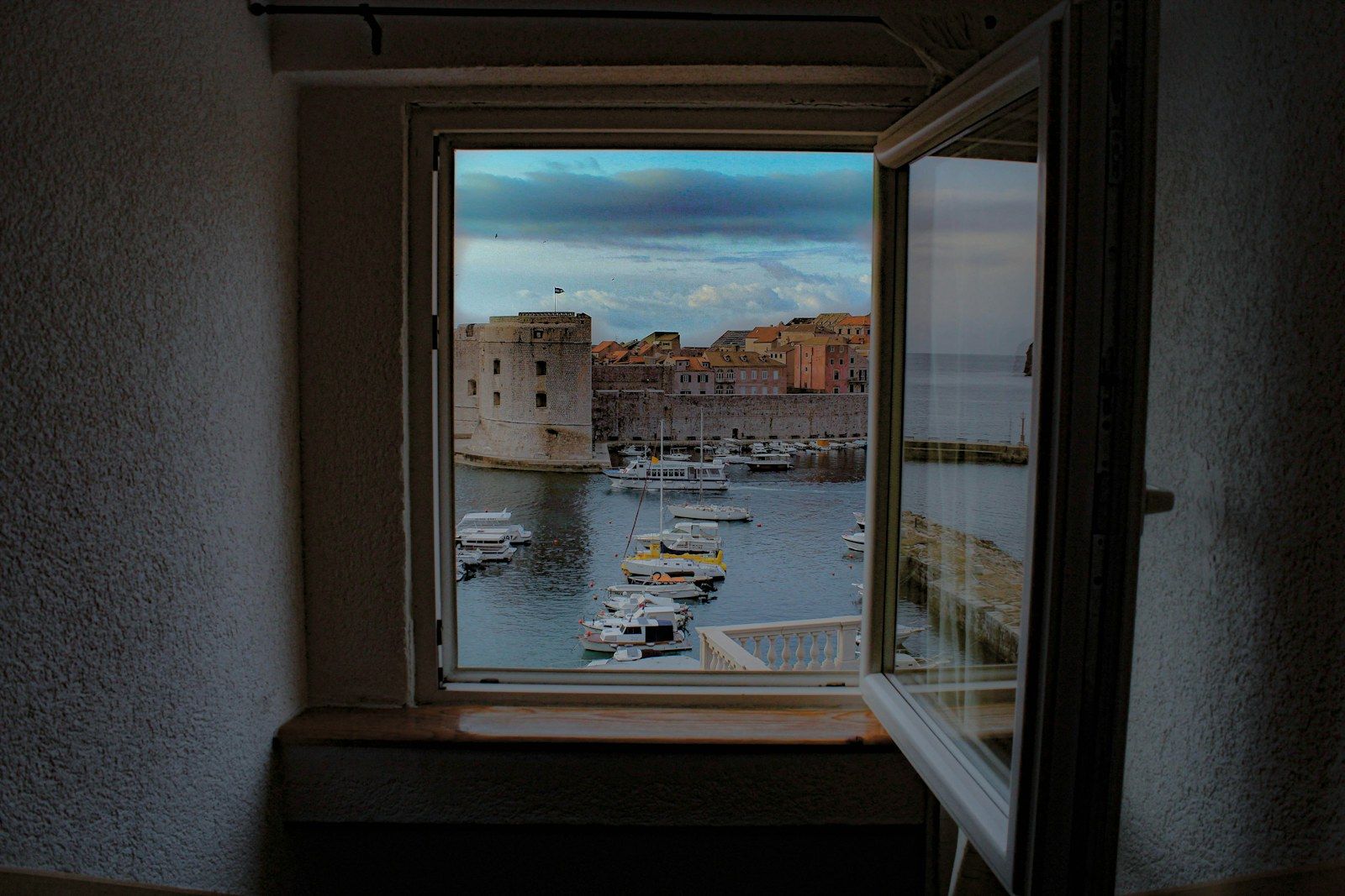 A bedroom window opening onto a harbour