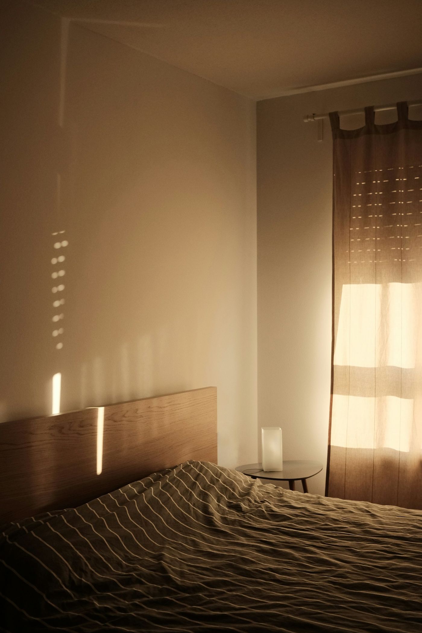 A bedroom at dusk with a warm lamp
