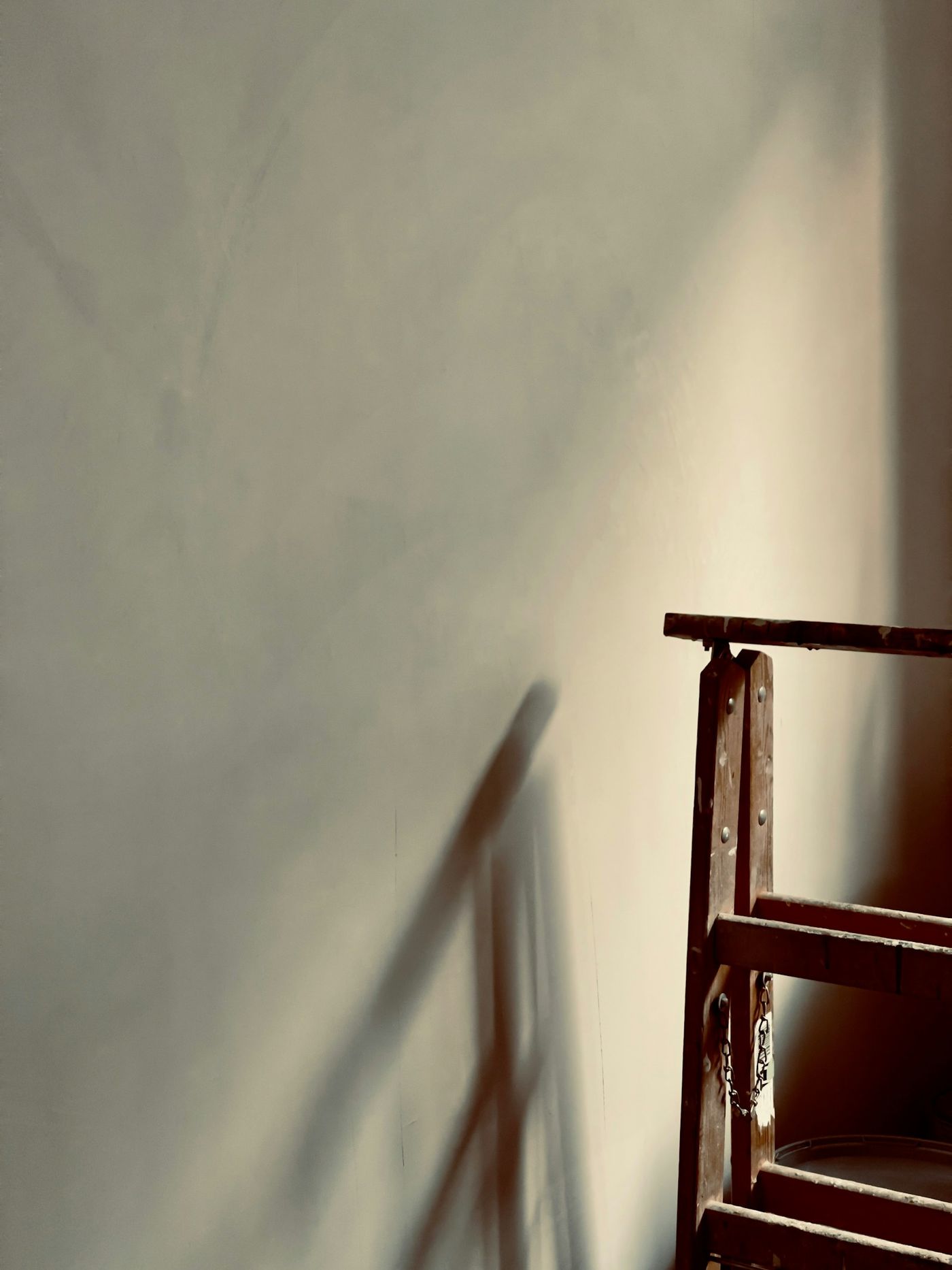 The shadow of a chair on a plaster wall