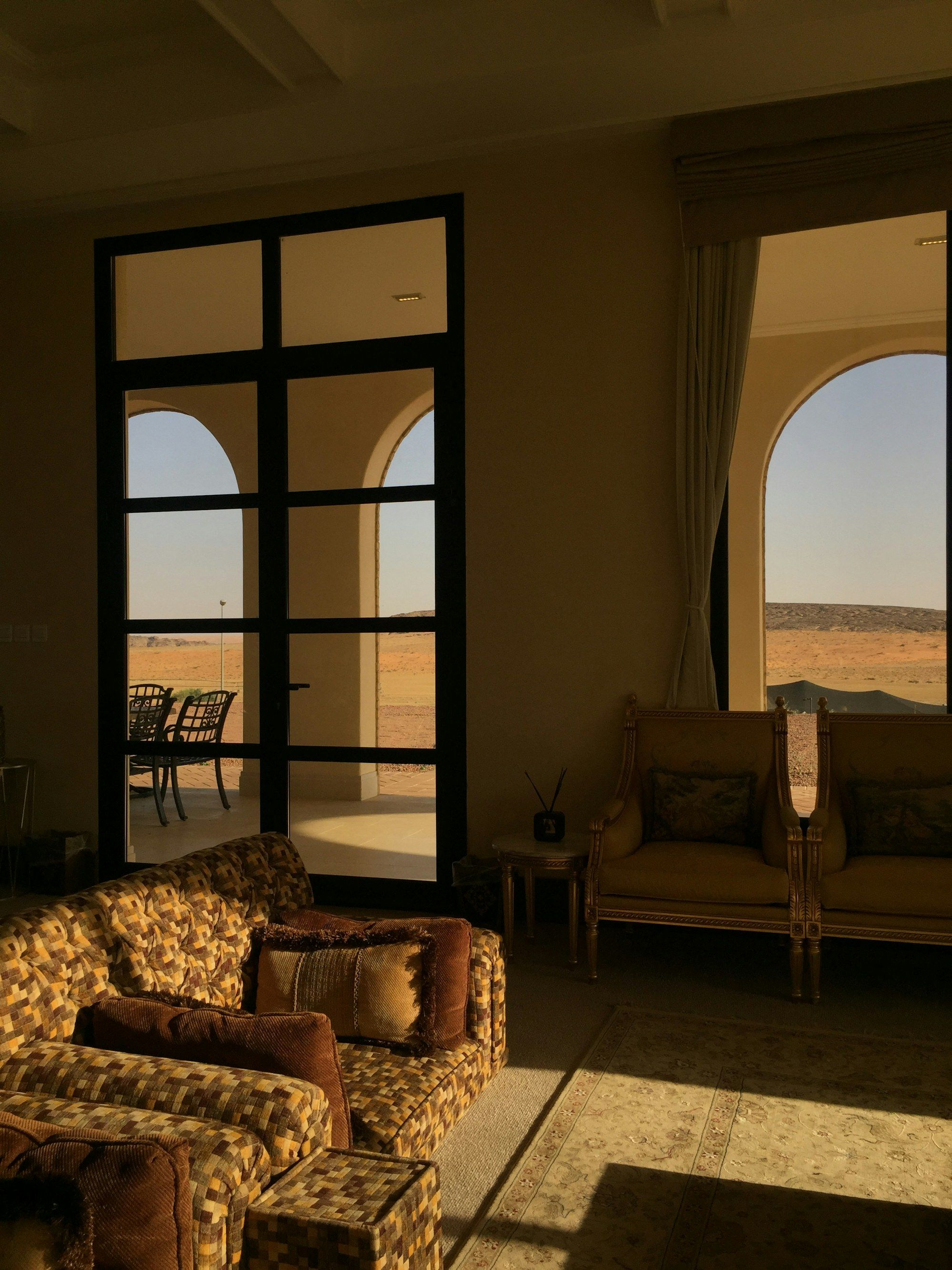 A warm living room with arched windows opening to the sea