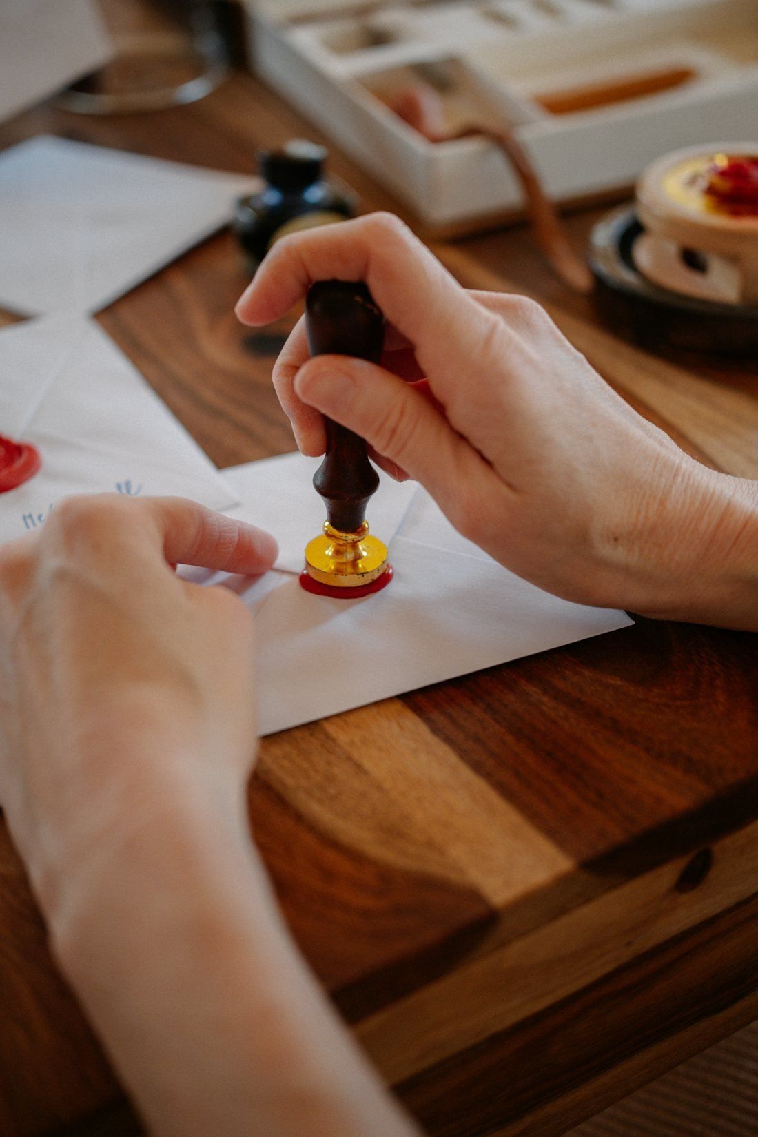 A hand pressing a seal onto paper